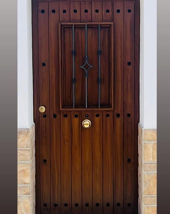 Puerta de madera con herraje metálico forjado por Ruiz